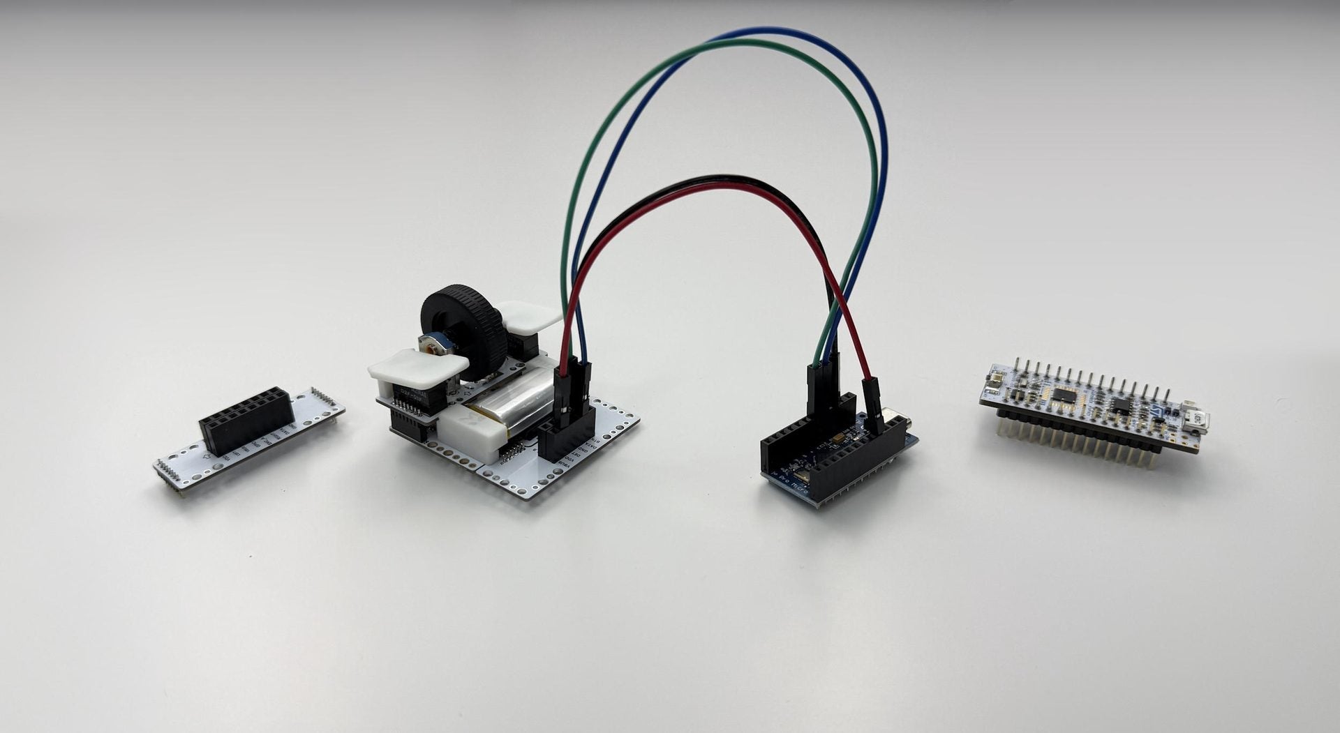 The moddoMOUSE wired to a Pro Micro Arduino via jumper cables, flanked by front and back expansion boards.